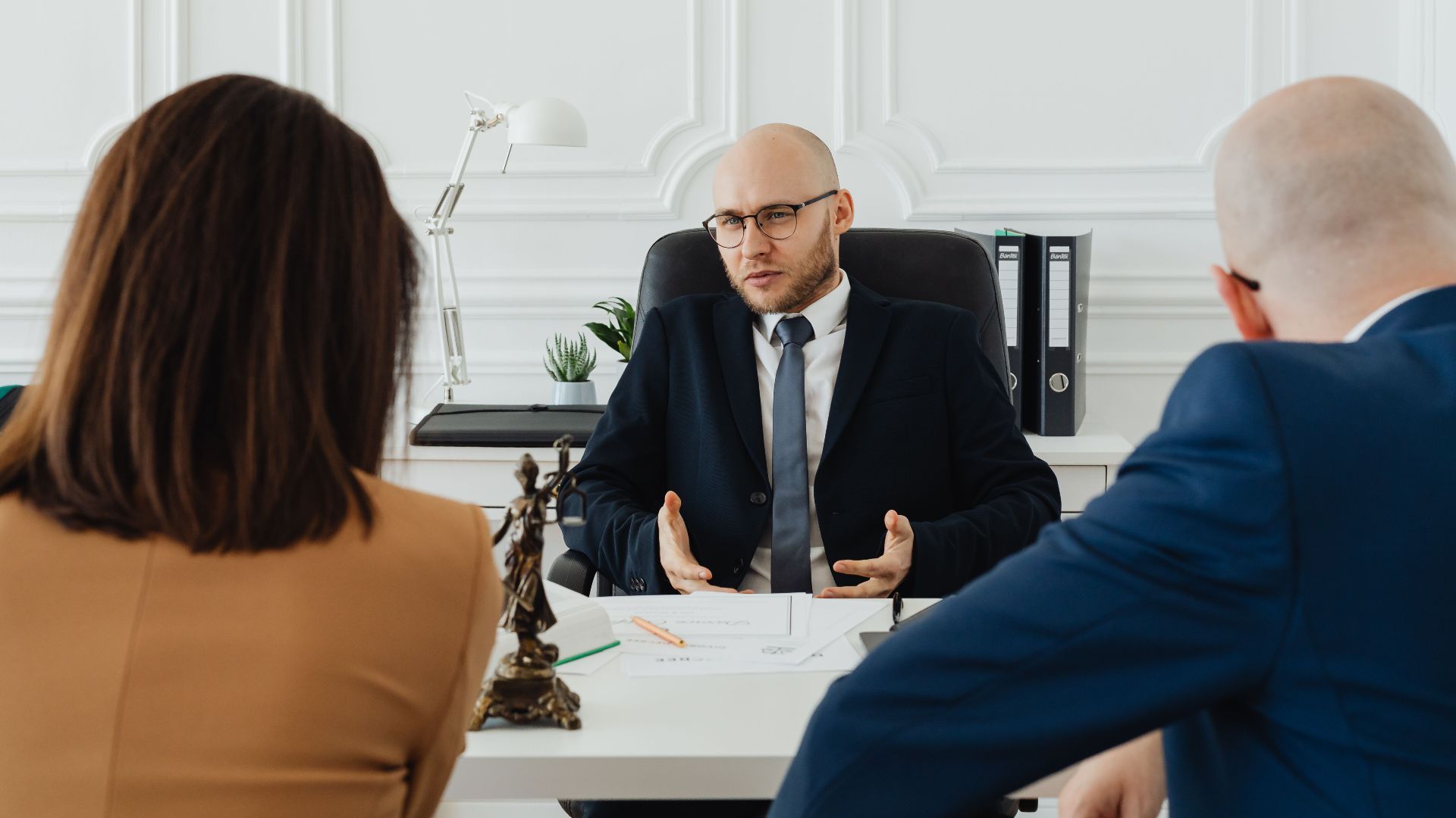 A professional business meeting with a lawyer and clients in a modern office setting.