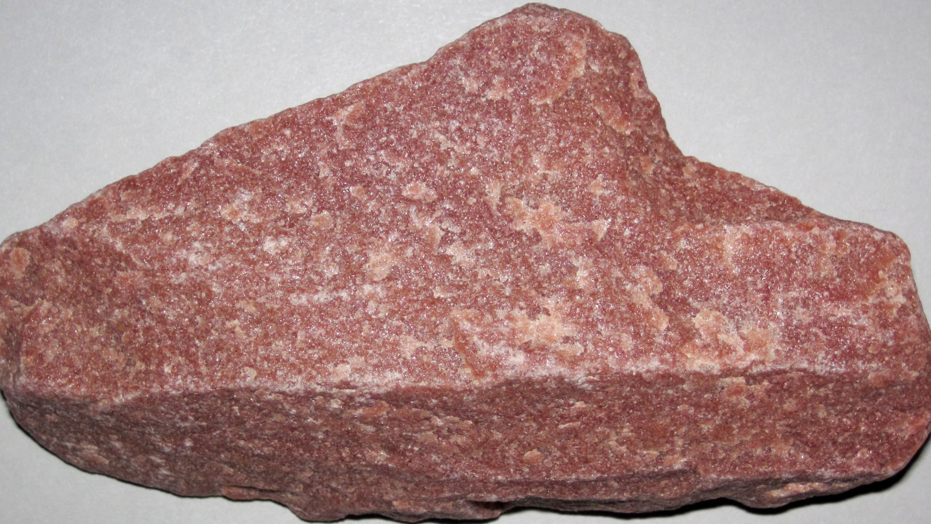 Quartzite from the Precambrian of the Transcontinental Arch, USA. (9.2 centimeters across at its widest)
Metamorphic rocks result from intense alteration of any previously existing rocks by heat and/or pressure and/or chemical change.  This can happen as 