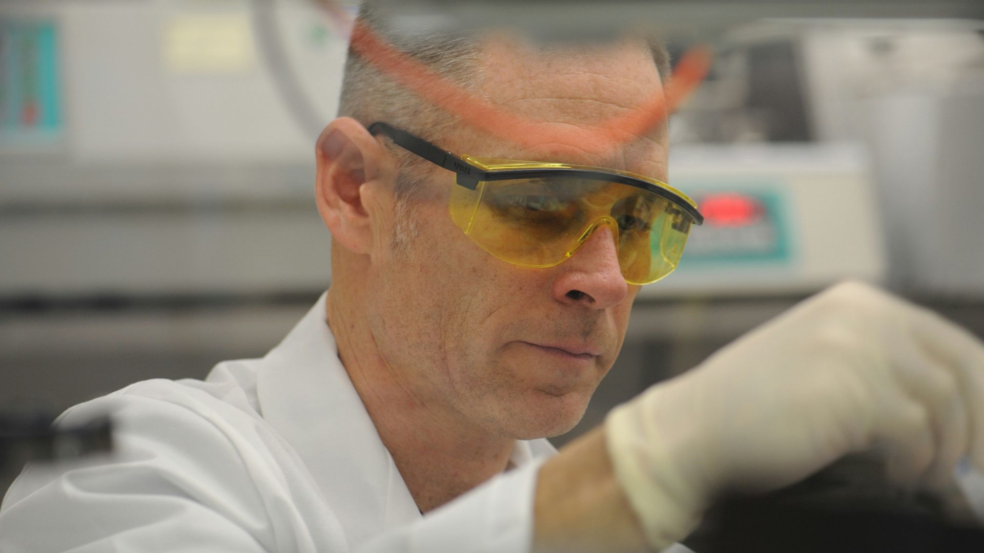 a man in a lab wearing safety goggles