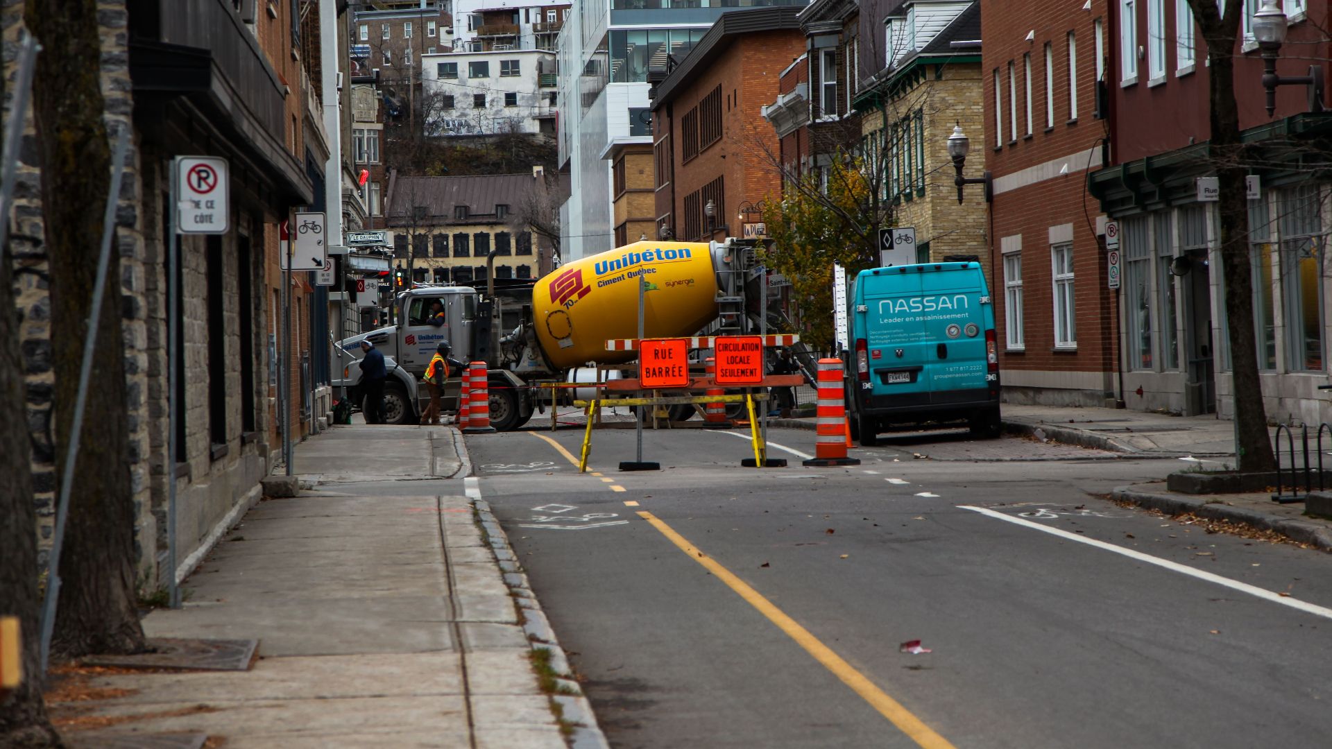 Street view of roadworks in historical Québec City, featuring construction equipment and buildings.