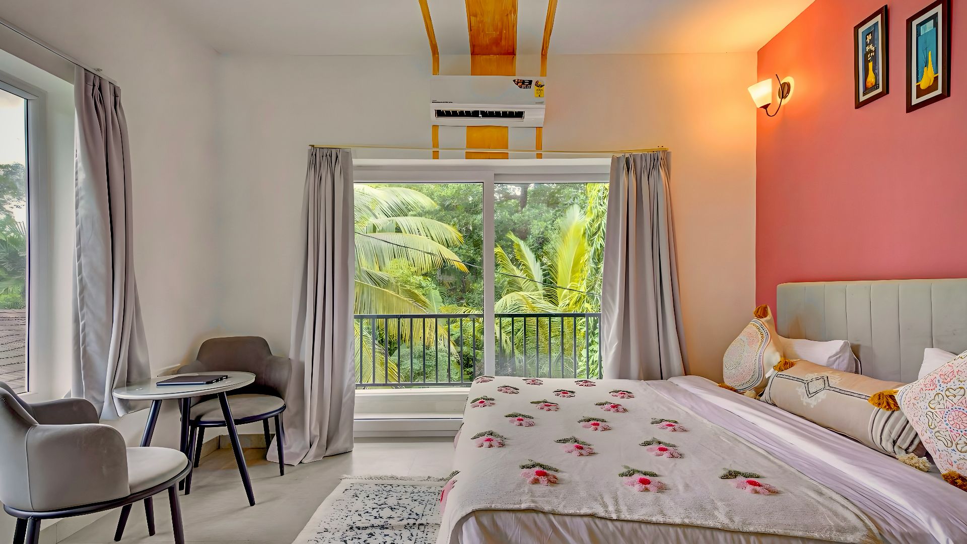 Modern bedroom with floral bed, pink wall, and tropical view