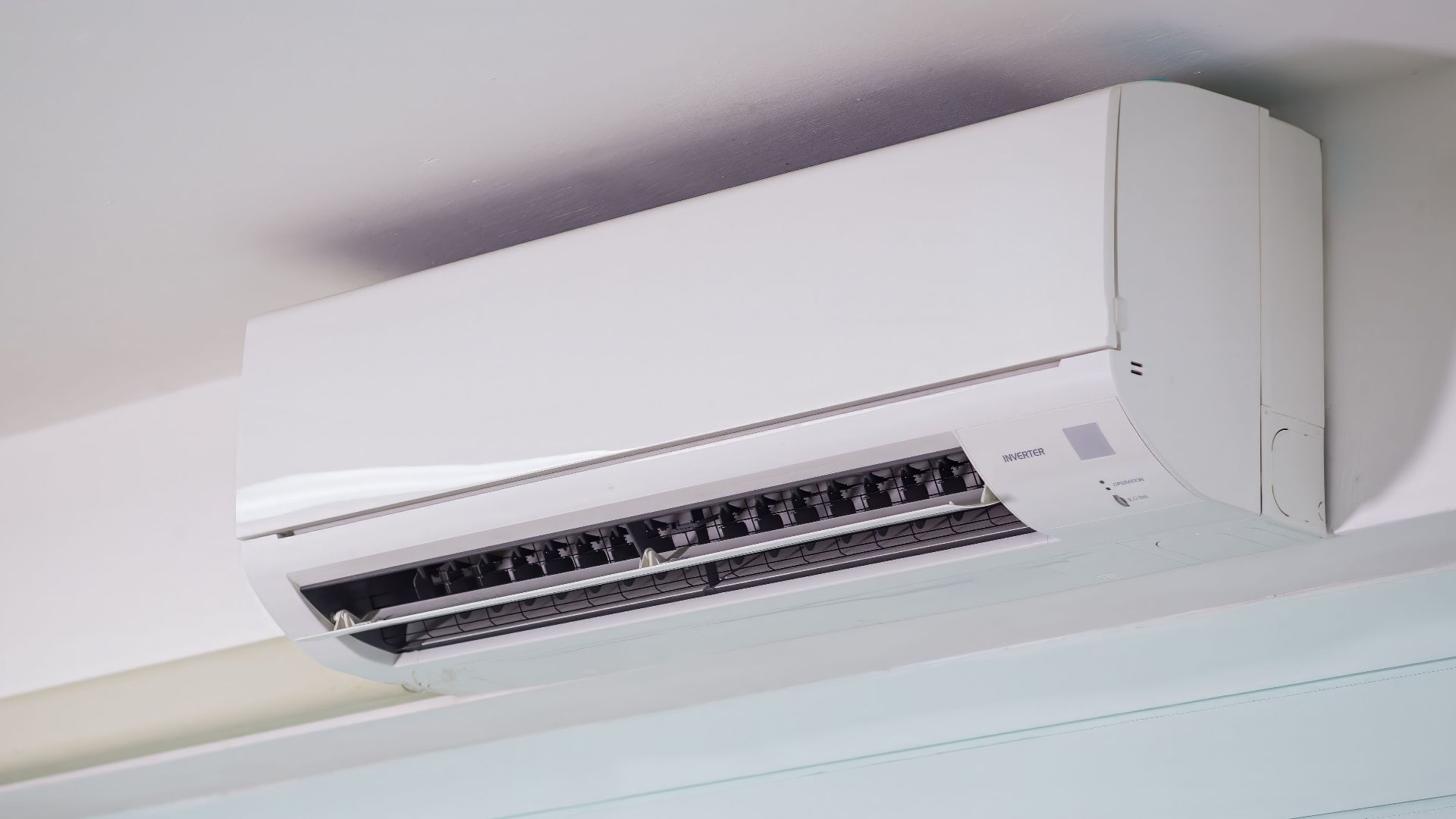 Close-up of a wall-mounted air conditioner indoors, showcasing sleek design for modern cooling solutions.