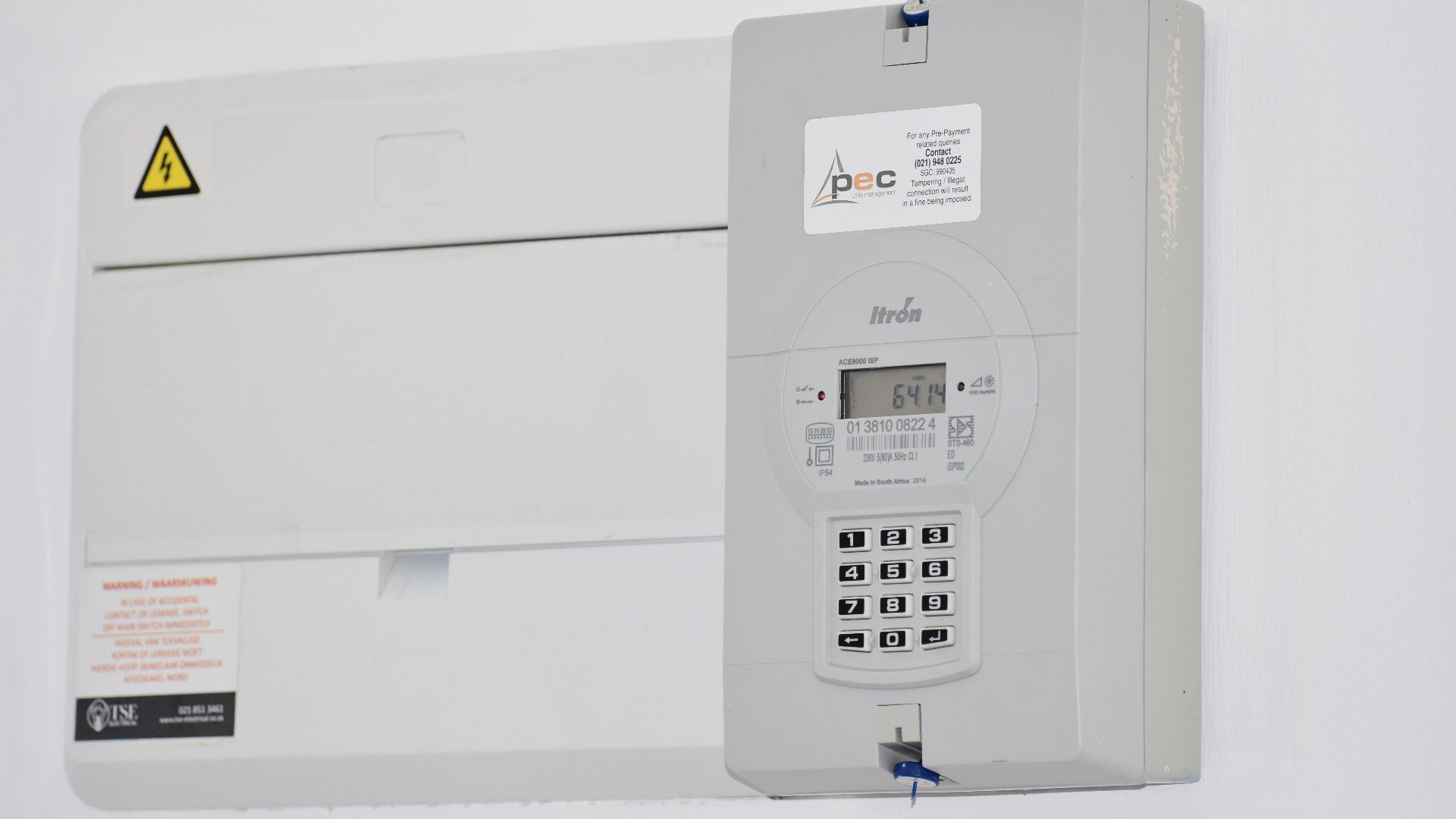 Electrical meter and fuse box on a white wall in Cape Town, South Africa, for energy monitoring or billing.
