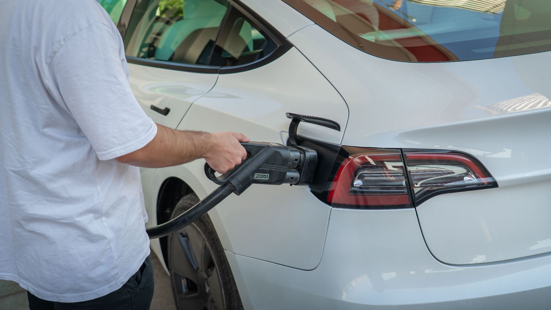 Electric car being charged at a station, highlighting eco-friendly transportation.