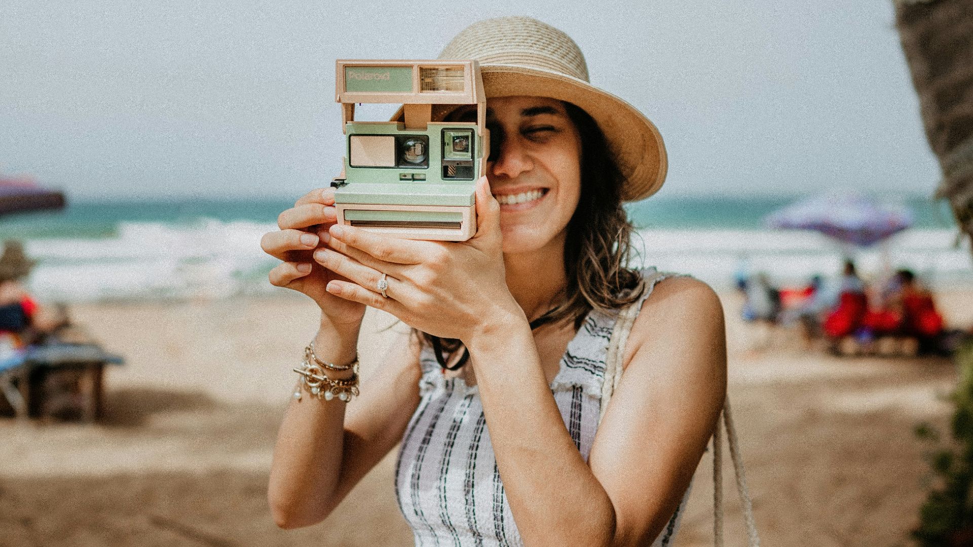 woman in white and blue stripe dress holding white and black camera