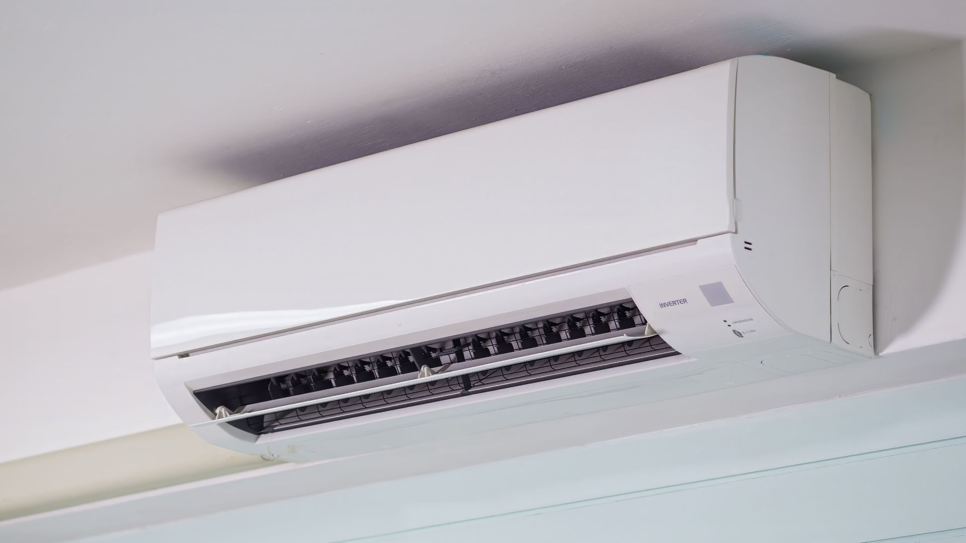Close-up of a wall-mounted air conditioner indoors, showcasing sleek design for modern cooling solutions.