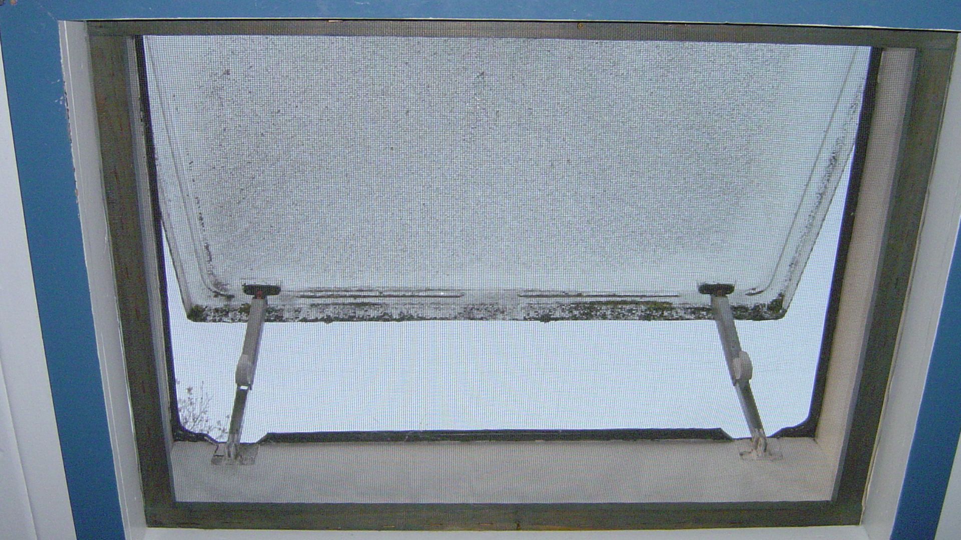 Sloped window with mesh window screen.