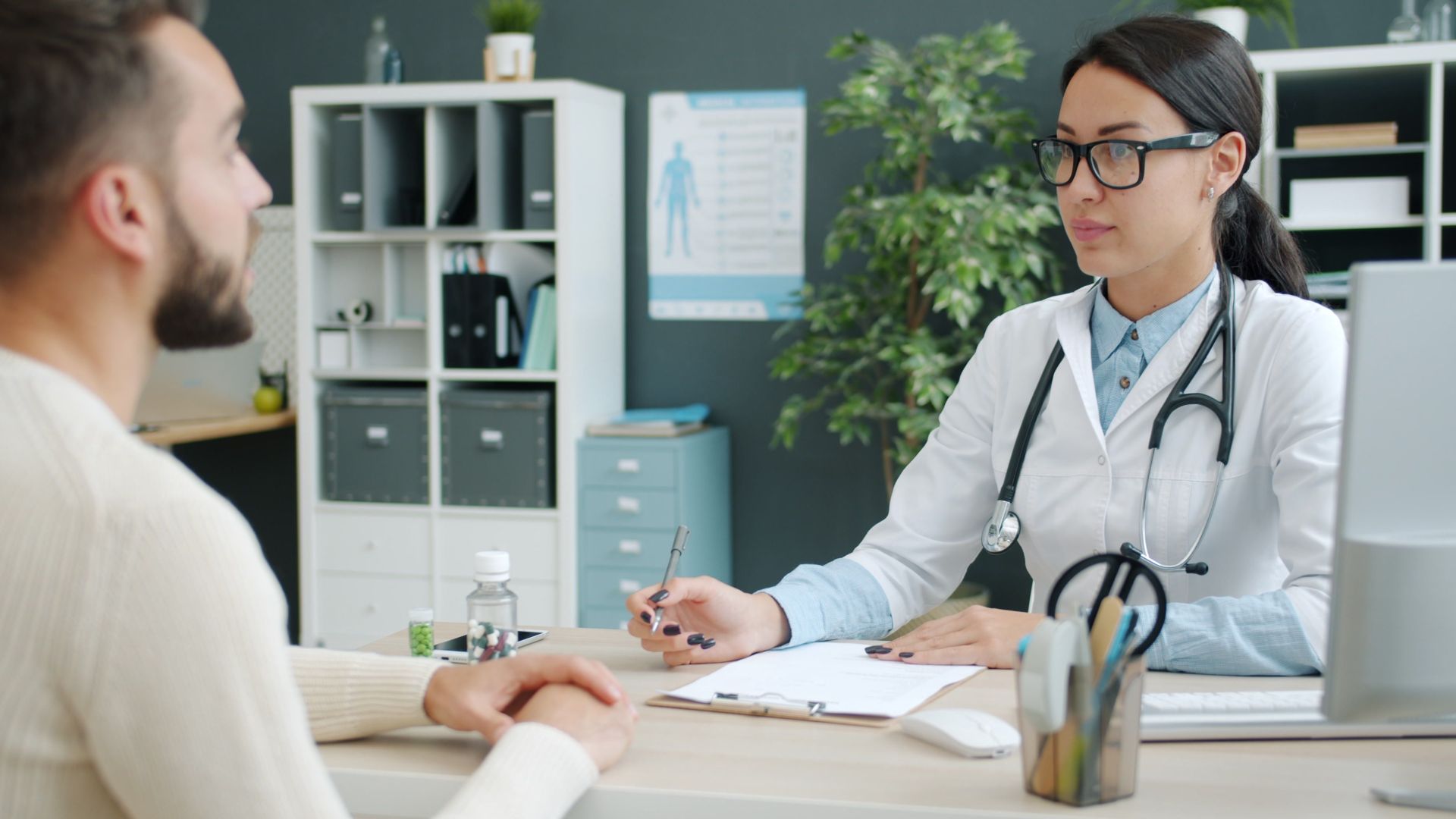 A doctor and patient engaged in consultation in a modern clinic office.