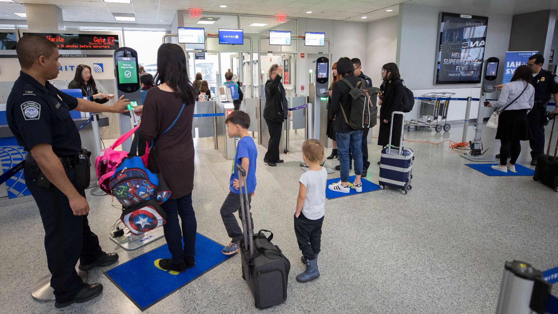 U.S. Customs and Border Protection, Office of Field Operations, officers assist passengers with taking biometric facial recognition photos prior to boarding a flight at Houston International Airport on February 12, 2018. ..Photographer: Donna Burton