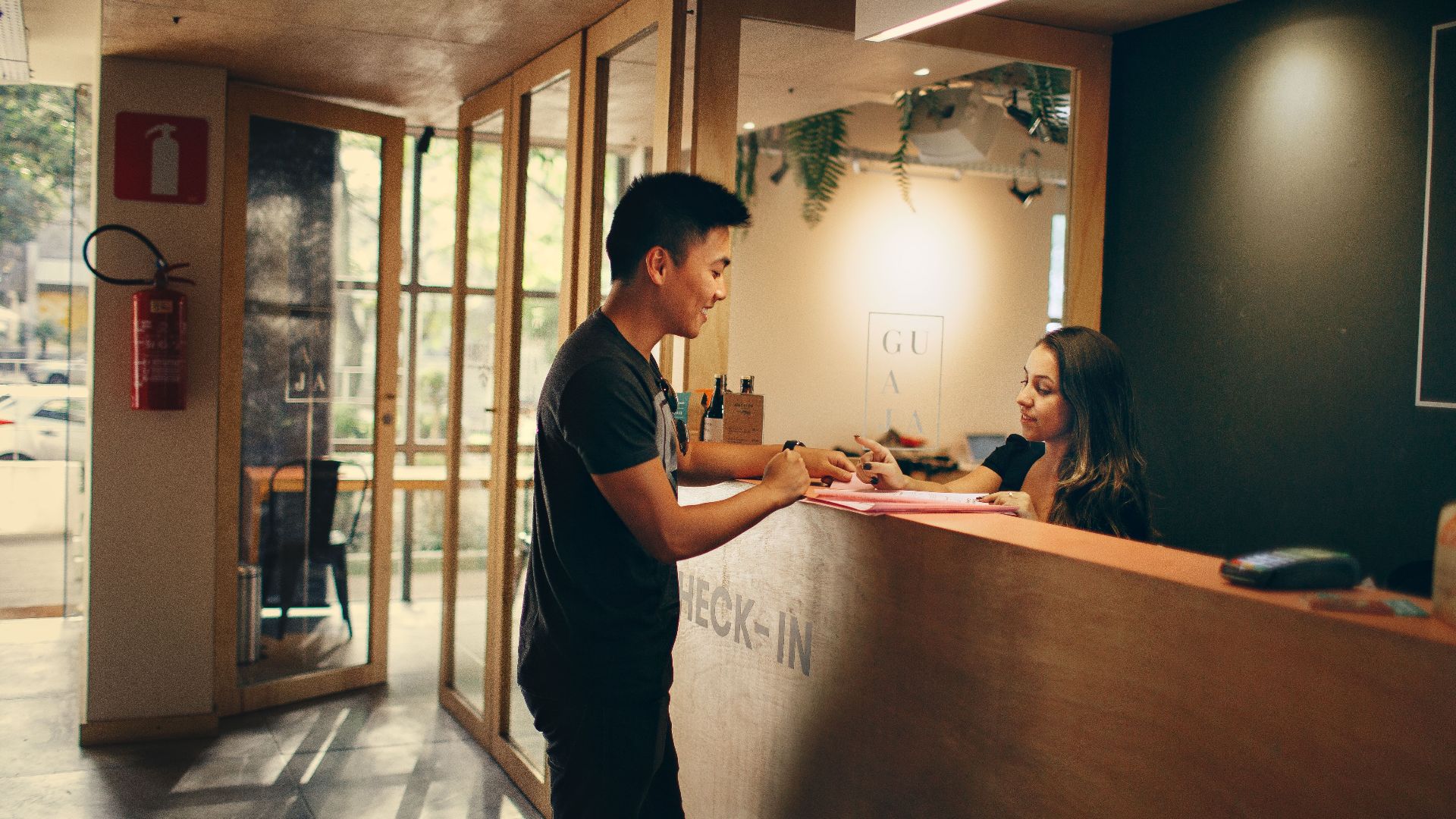 A customer checks in at a hotel reception desk in Belo Horizonte, Brazil.