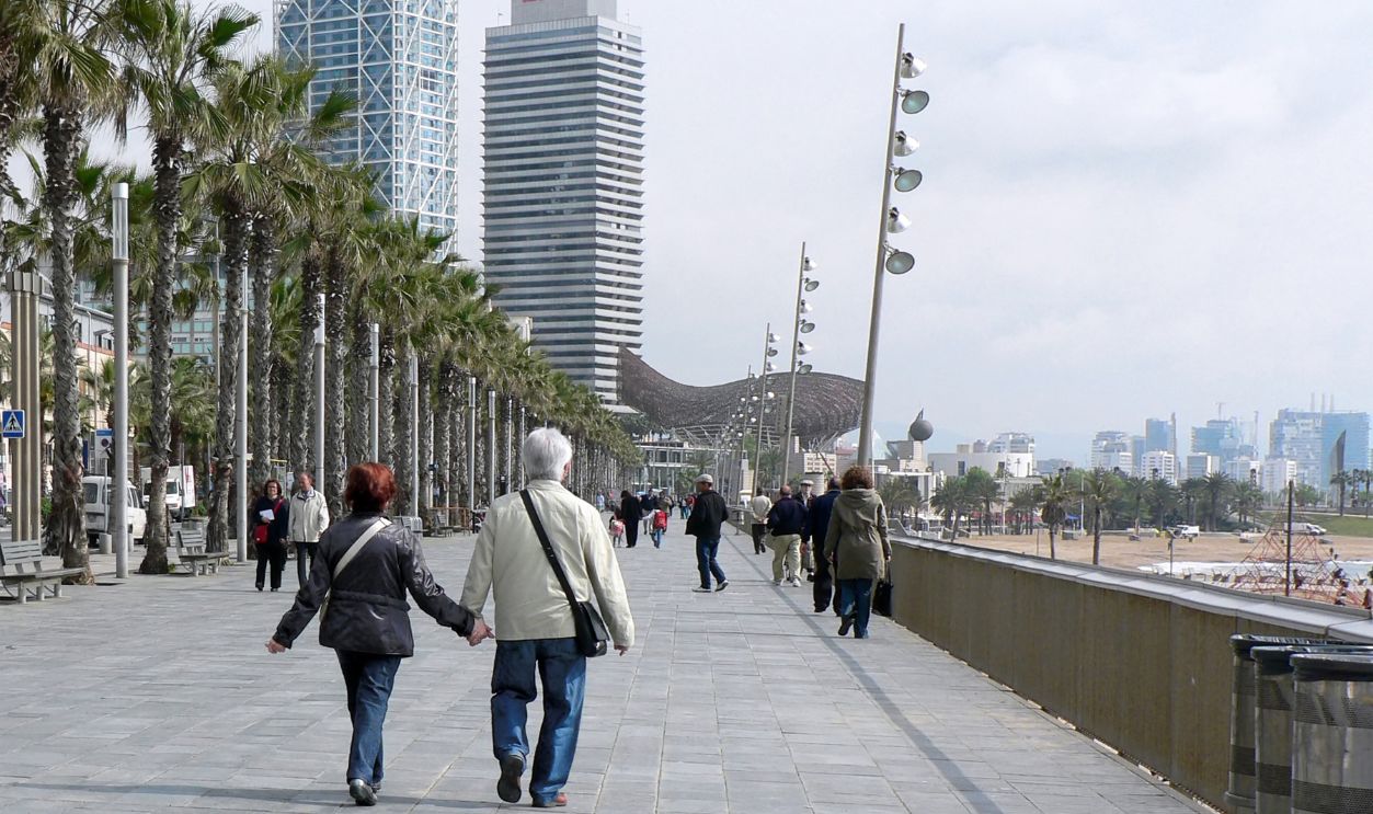 BARCELONA, SPAIN - MAY 7: Unidentified couple strolls along the Mediterranean seashore on May 7, 2010. The fish-shaped sculpture is