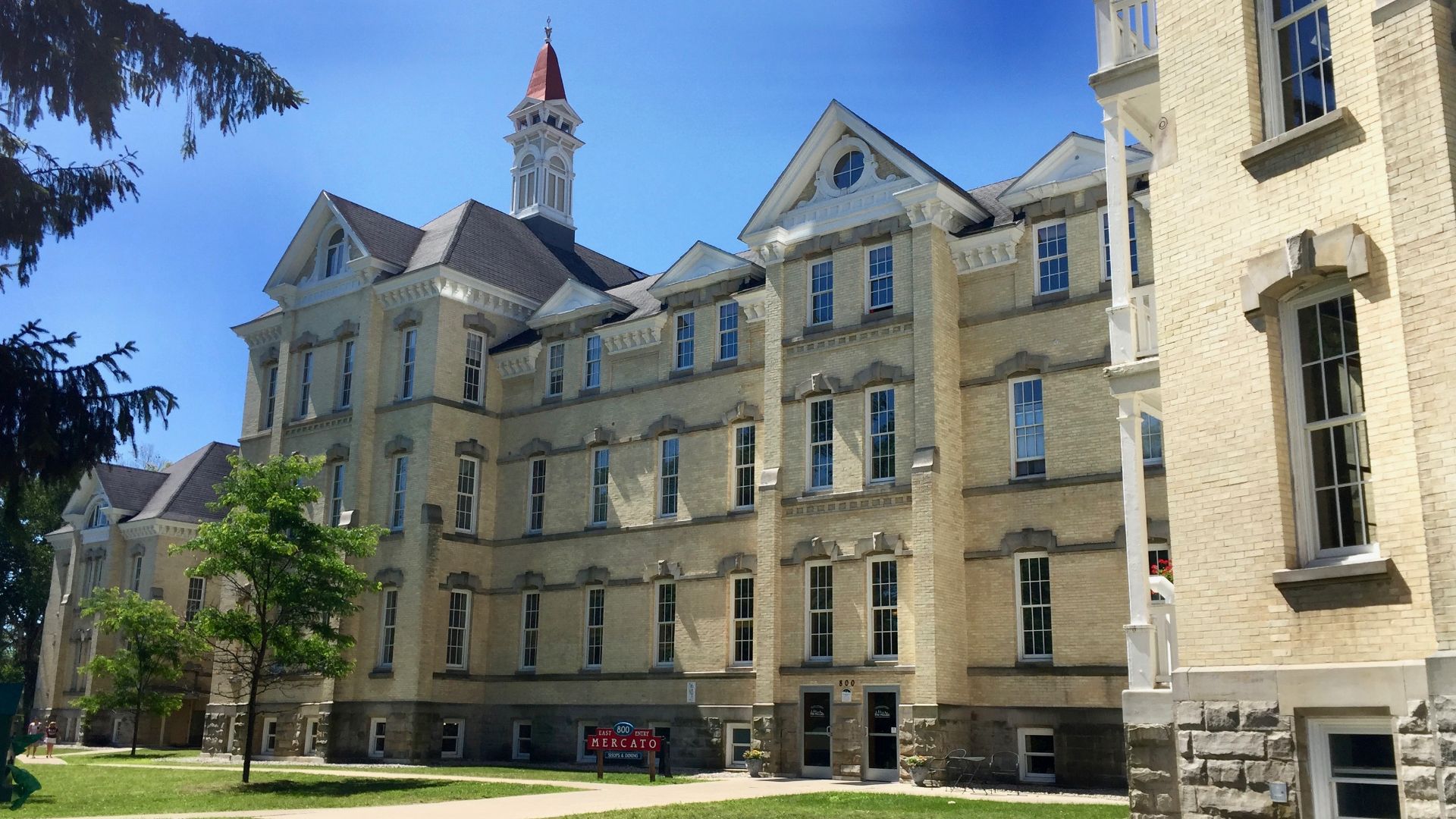 The old Traverse City State Hospital (now the Village at Grand Traverse Commons) in Traverse City, Michigan consists of a series of Kirkbride-style light cream-colored brick pavilions arranged in a zig-zagging pointing arrangement that falls back from the