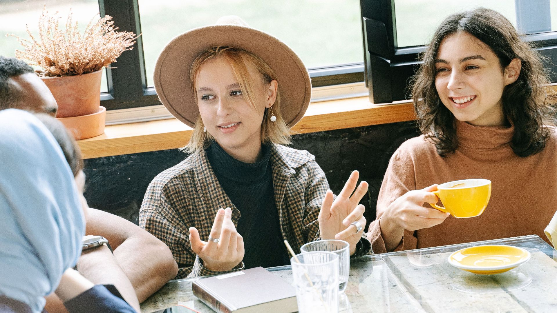 A diverse group of friends bonding over coffee indoors, showcasing unity and friendship.