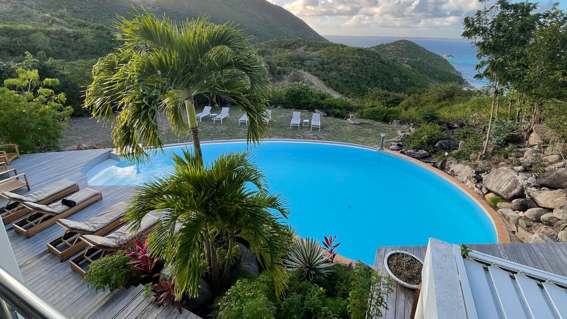 A serene pool with stunning Caribbean island views and lush greenery.