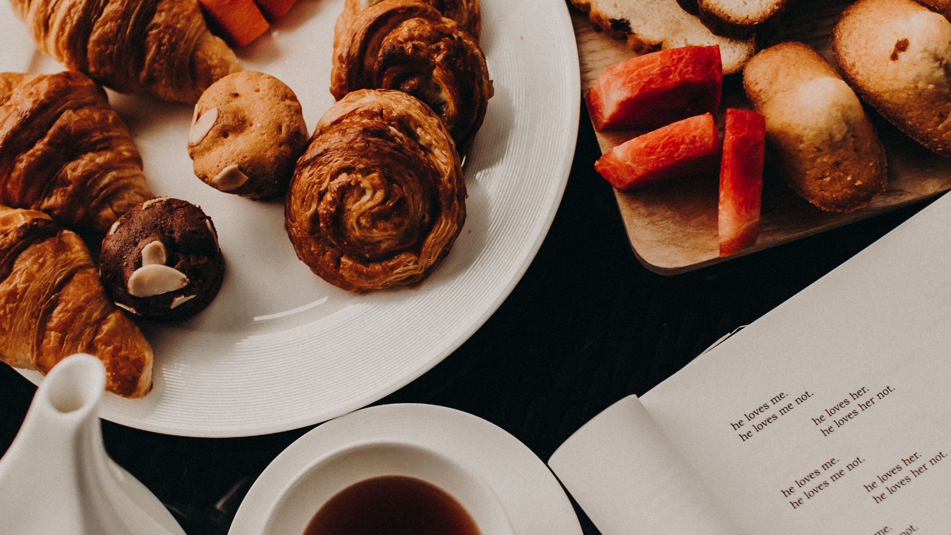 A delightful breakfast arrangement featuring croissants, pastries, and a cup of tea for a cozy morning.