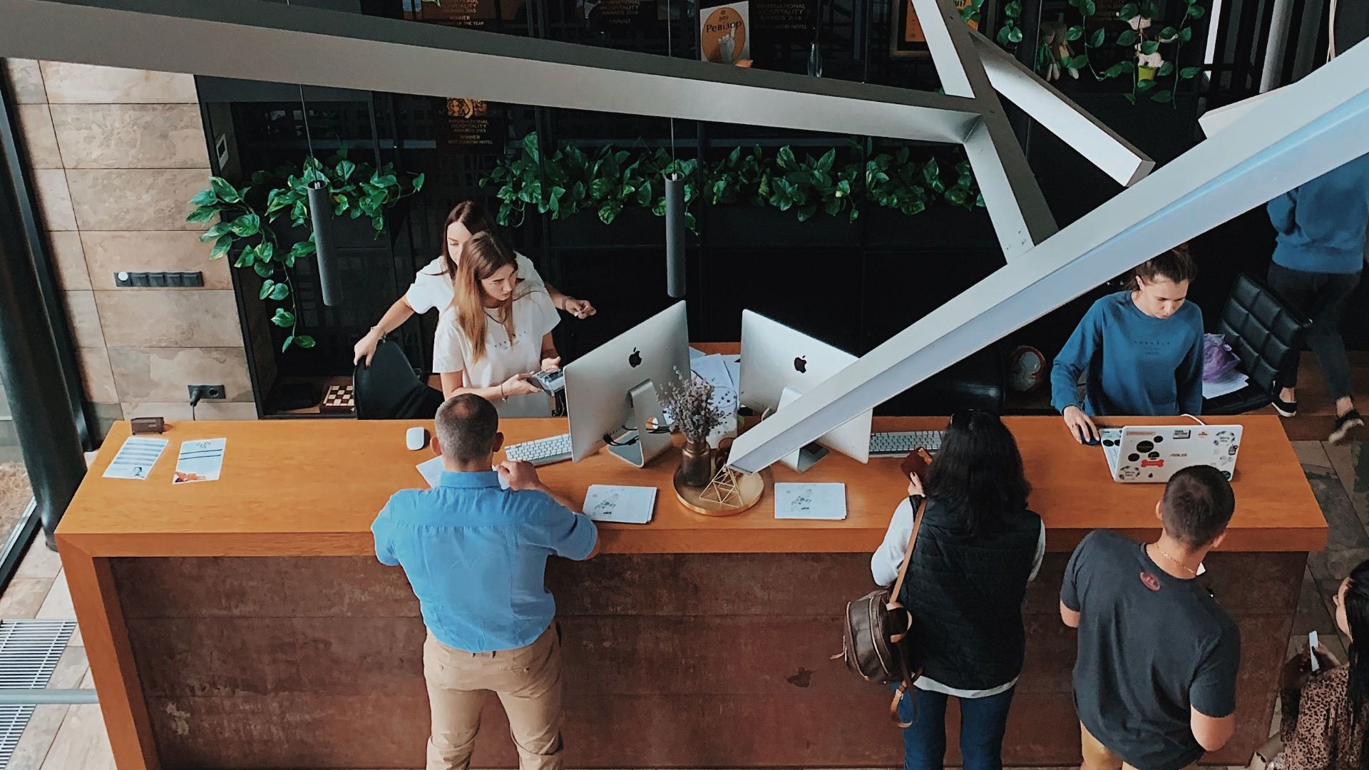 Aerial view of a modern hotel reception with people interacting at the desk in Sosnivka, Ukraine.