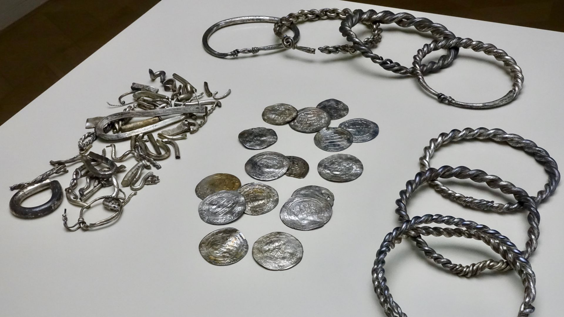 01. Silver hoard (in Norwegian: sølvskatt) found in 1844 at Teisen Farm in Oslo, Norway: seven arm rings (probably made from melted down coins), one ingot, many pieces of hack-silver, 16 whole and many pieces of  Arabian and Persian (Kufic) coins. The new