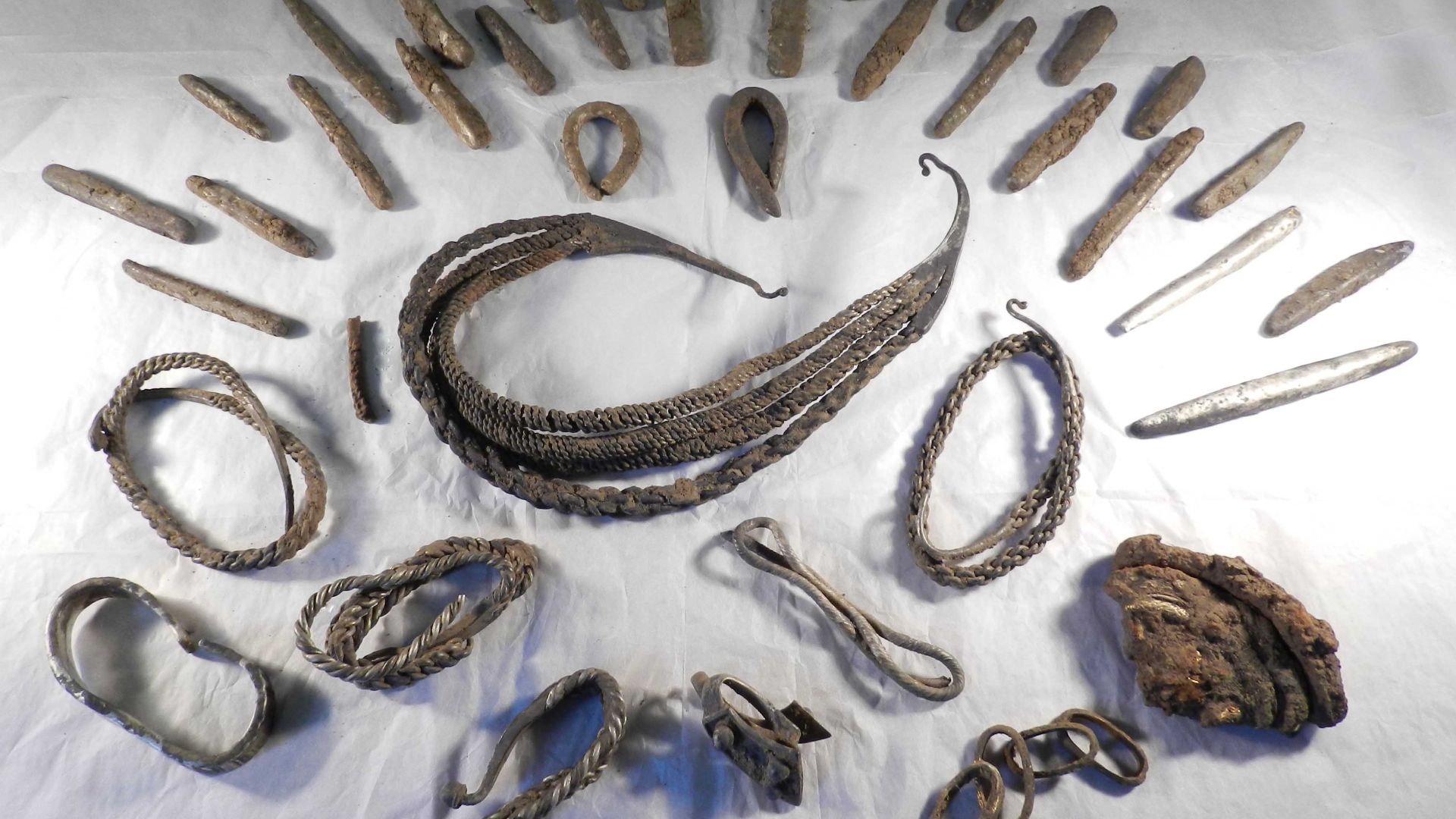 PAS Database ID: YORYM-CEE620 Viking hoard dating 850-950, found near Bedale, North Yorkshire in October 2012. Hoard comprises 1 iron sword pommel with gold foil plaques, 4 gold hoops a sword hilt, 6 small gold rivets, 4 silver collars and neck-rings, 1 s