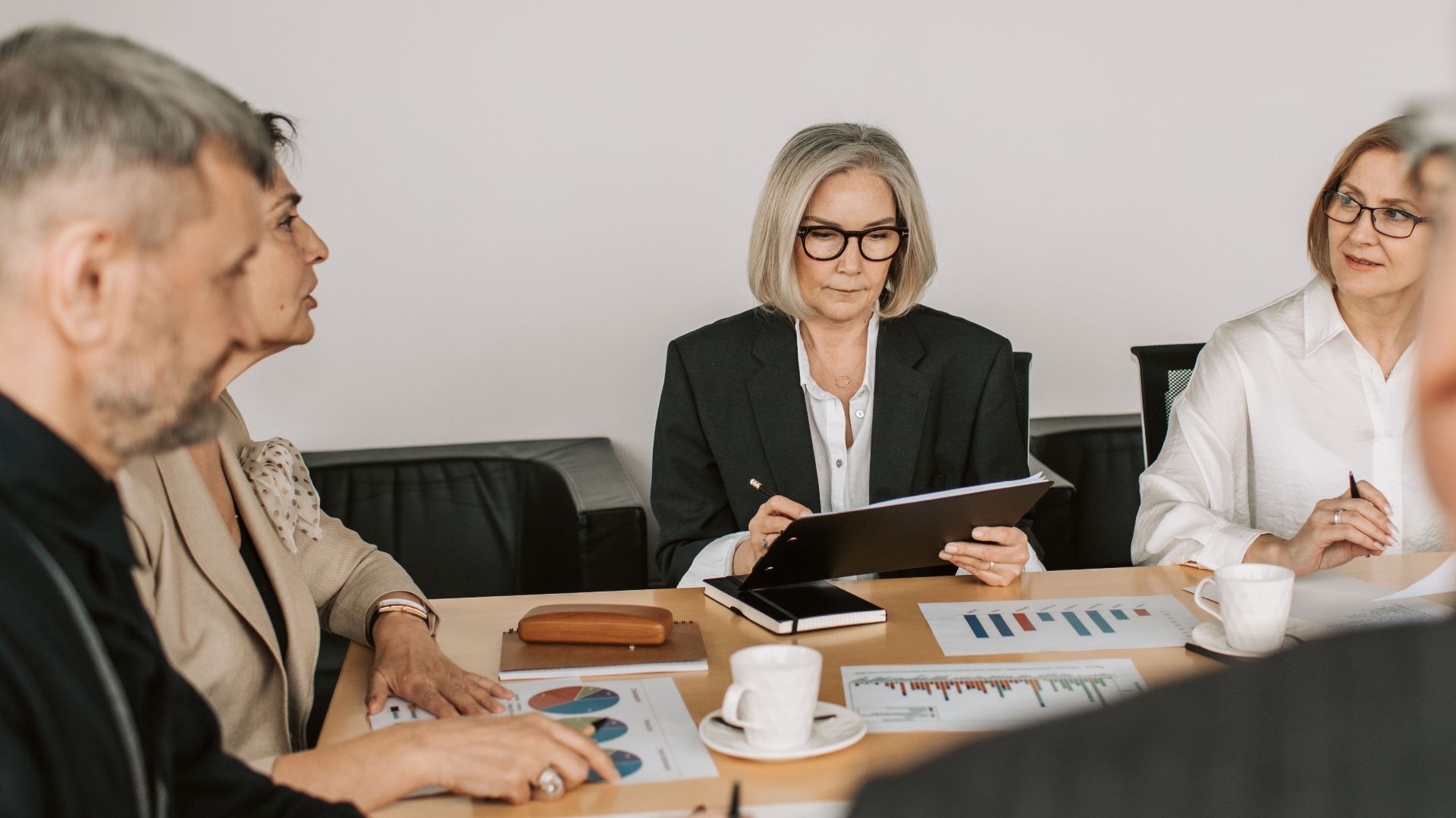 Senior professionals engaged in a collaborative business meeting in a modern office setting.