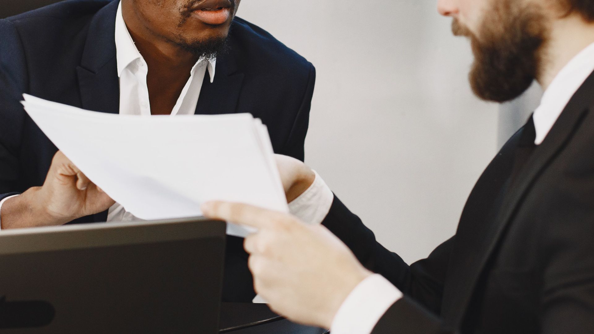 Professionals examining documents in an office business meeting setup.