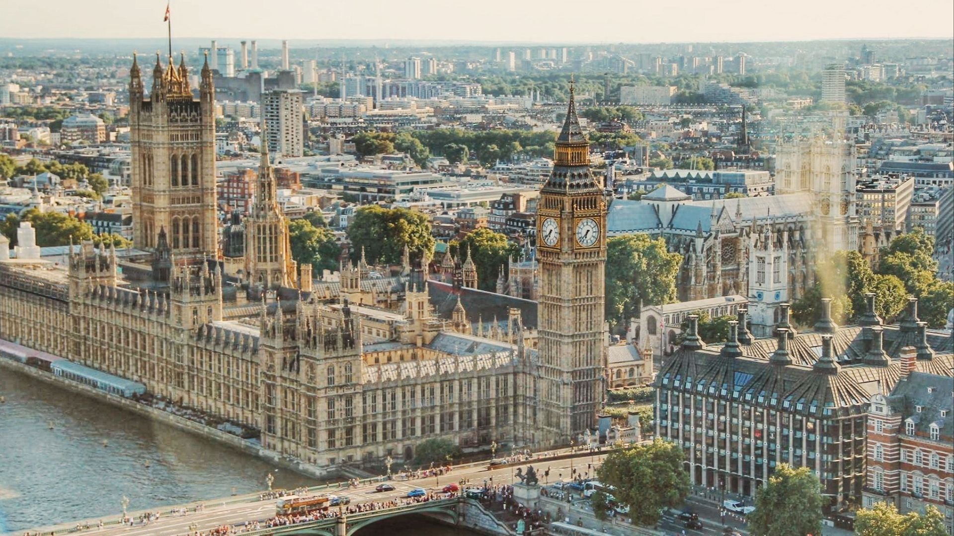 Stunning aerial view of London's iconic Big Ben and the river Thames under daylight.