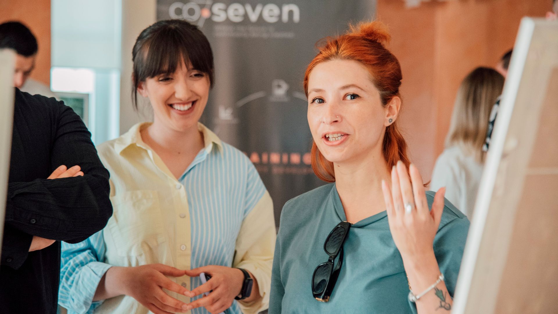 Two women engaging in a lively discussion during a workshop session indoors.
