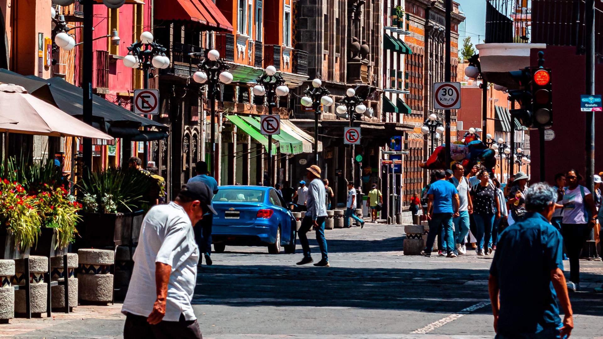 Colorful architecture and lively street scene in Puebla, Mexico on a sunny day.