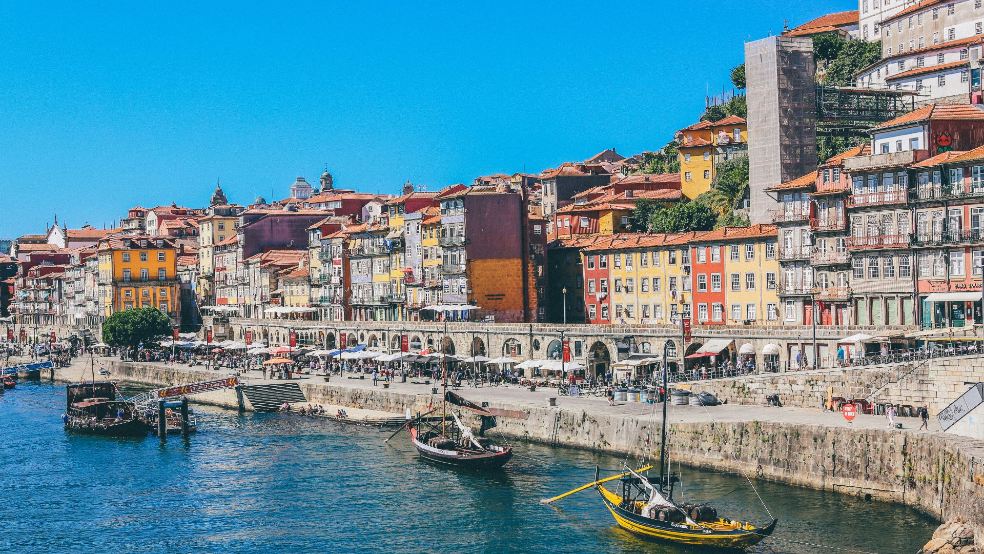 Traditional wooden boats on the Douro River in Porto, Portugal, with colorful buildings