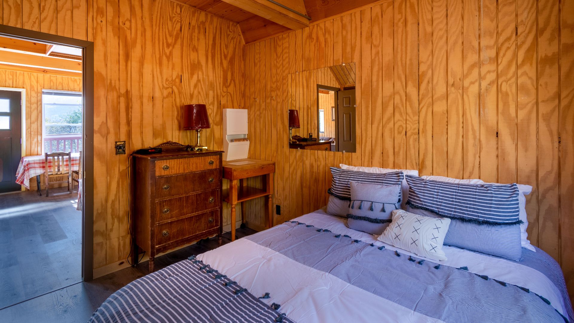 Inviting wooden cabin bedroom with cozy decor and natural light.