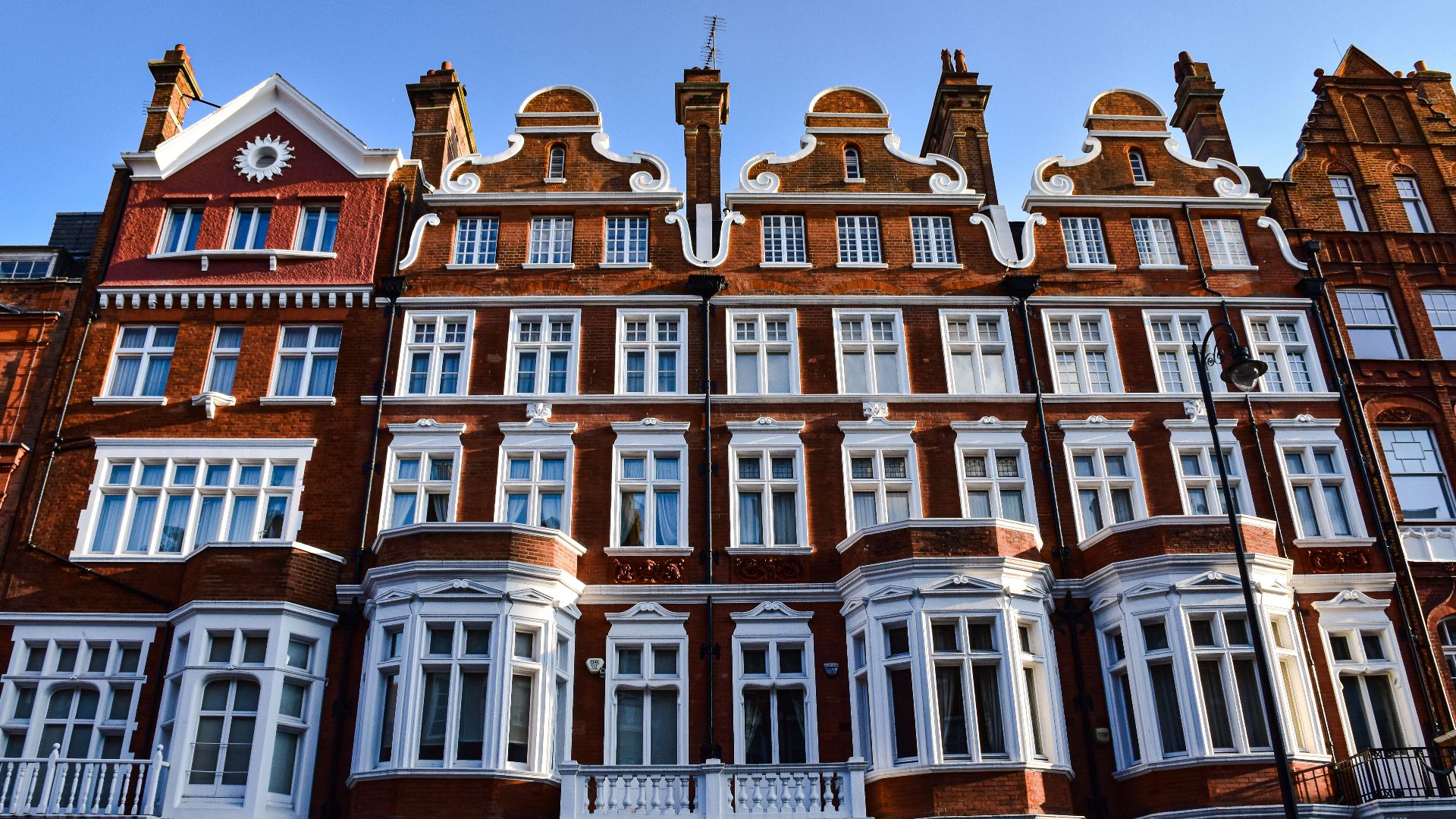 Victorian-style red brick building in London with ornate windows and detailed facade.