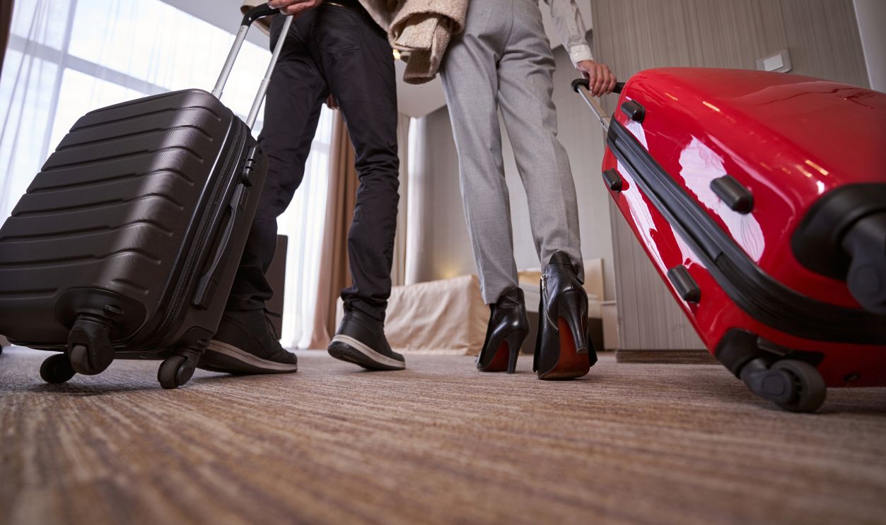 Man and woman with baggage in hotel room