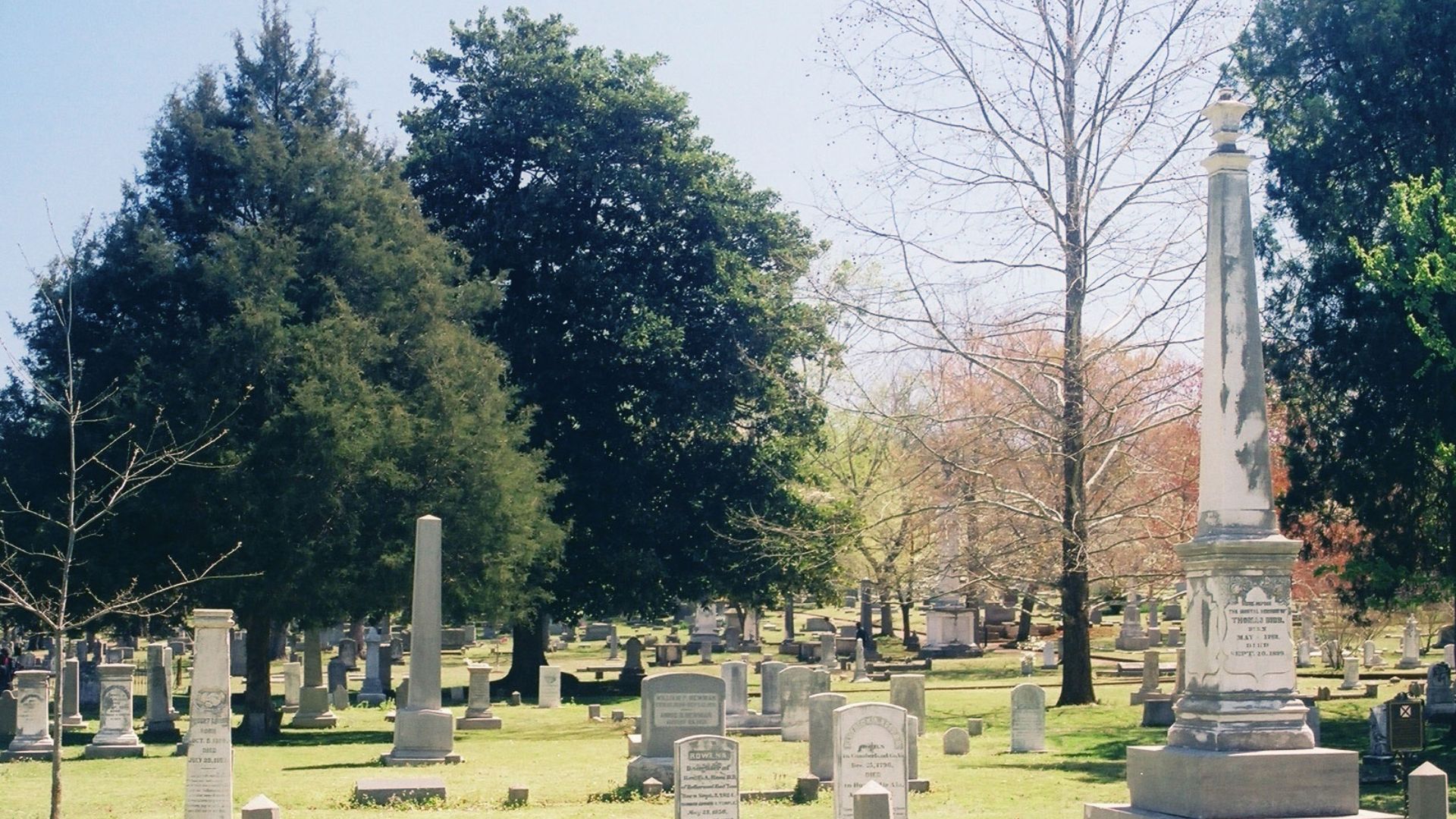 A view of Maple Hill Cemetery in Huntsville, Alabama, looking southeast through the older sections of the cemetery. The tall obelisk pictured at right is the monument of Alabama Governor Thomas Bibb. In the background to its left, partially obscured by tr