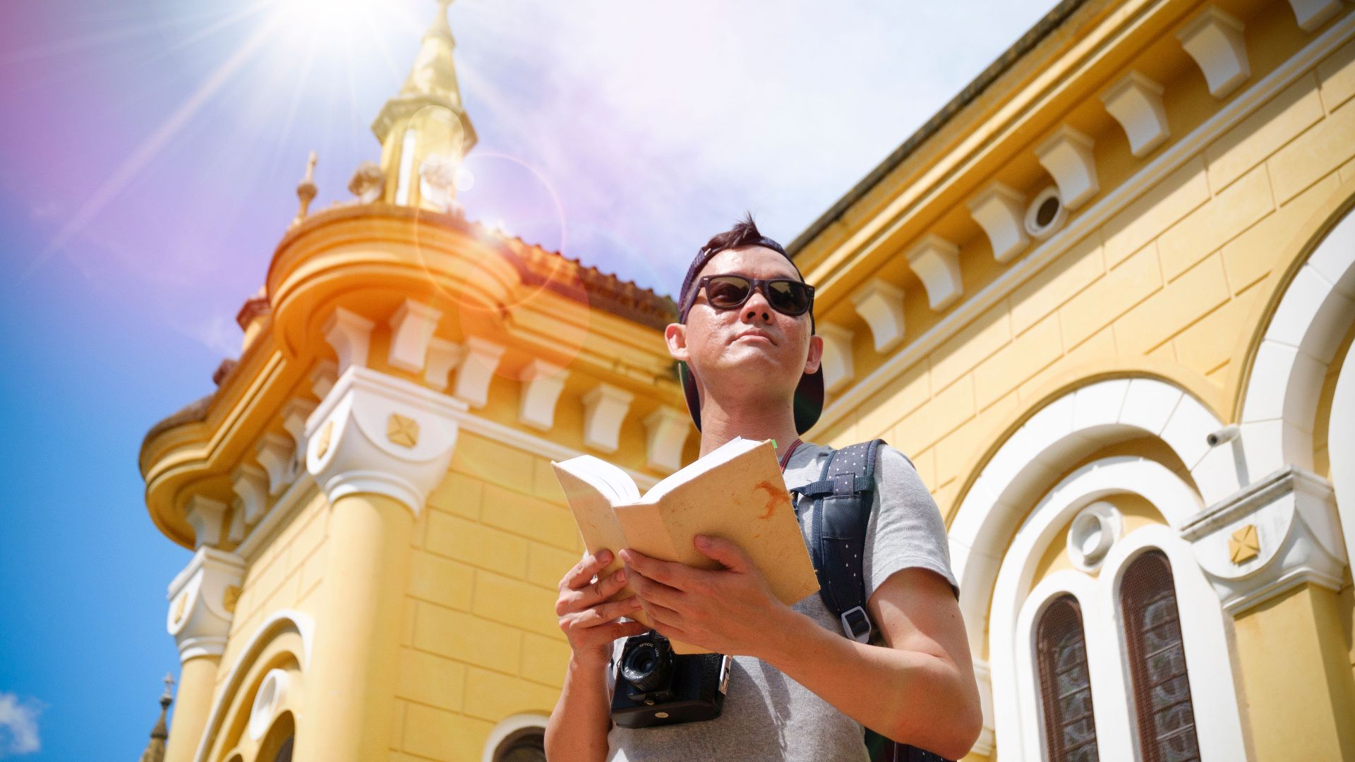 A tourist with a camera explores a sunny historical landmark, enjoying the summer day.
