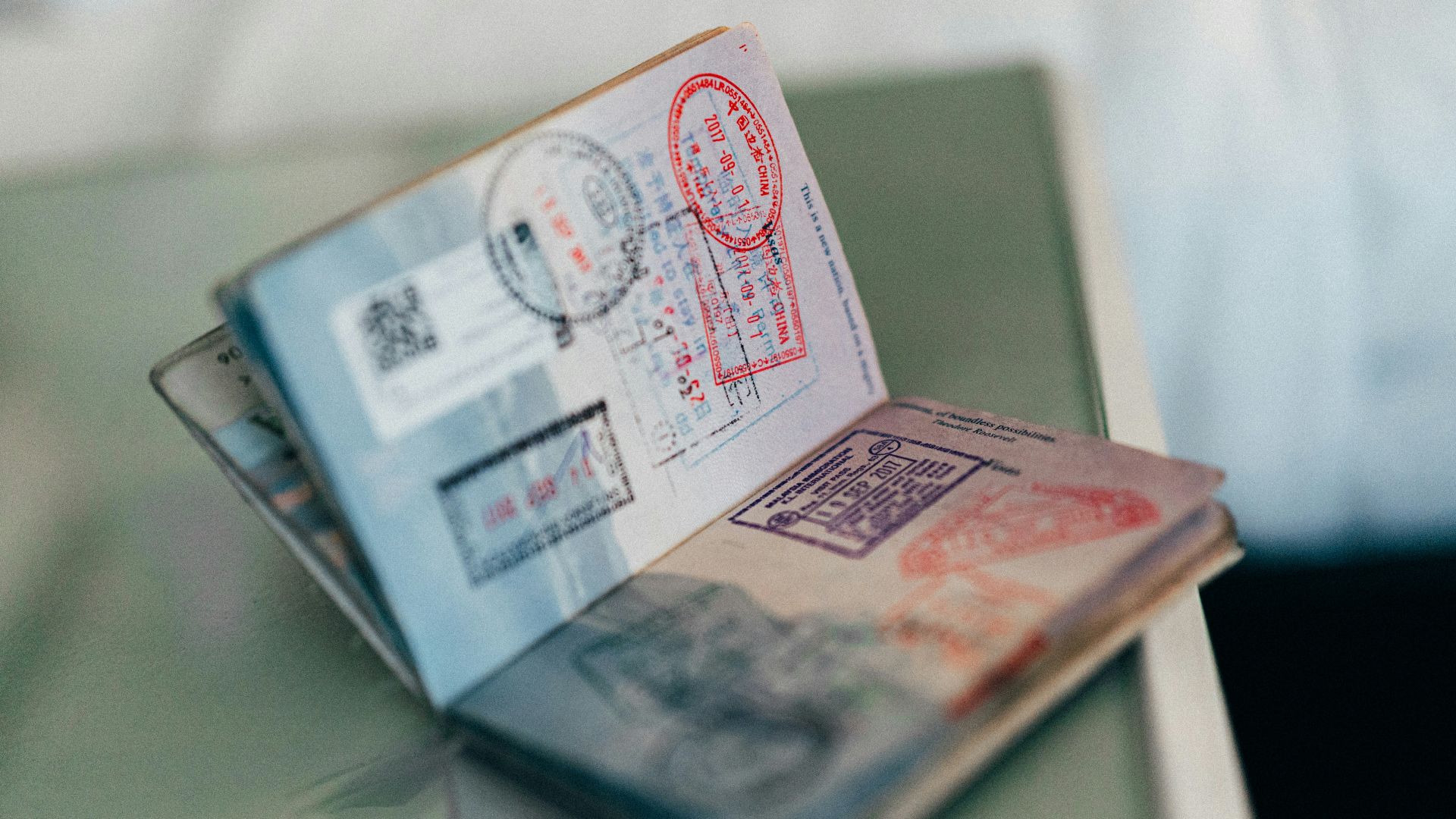 An open passport with multiple colorful ink stamps on the pages