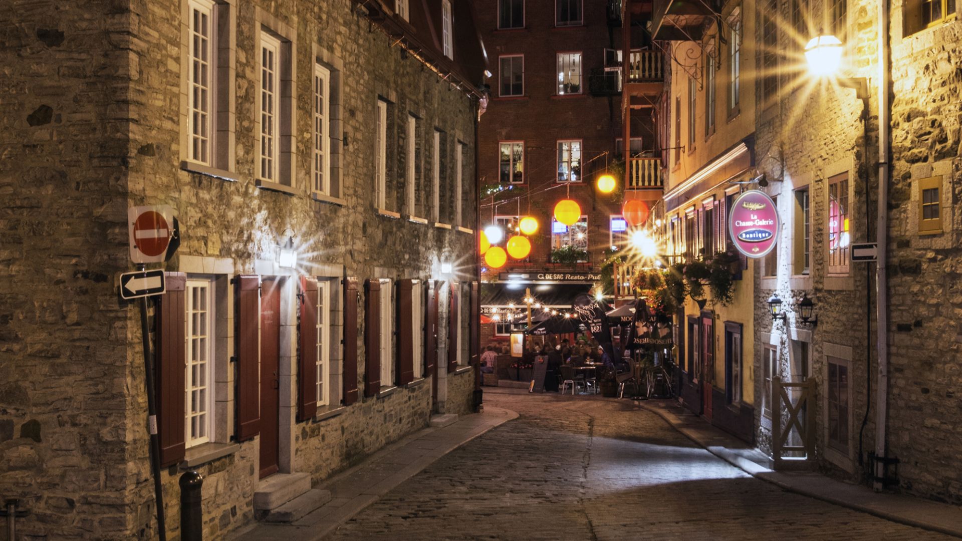 Rue du Petit-Champlain at night in Quebec City, with Château Frontenac in the background.