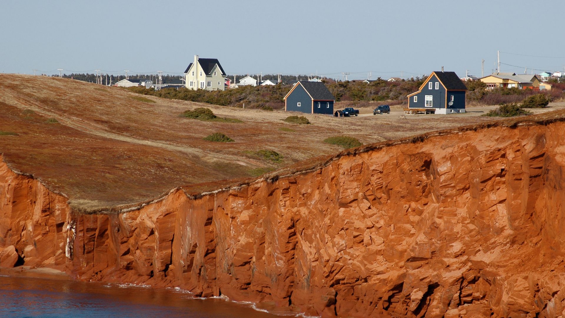 House by a typical red cliffside, Magdalen Islands (Iles de la Madeleine), Quebec, Canada.
