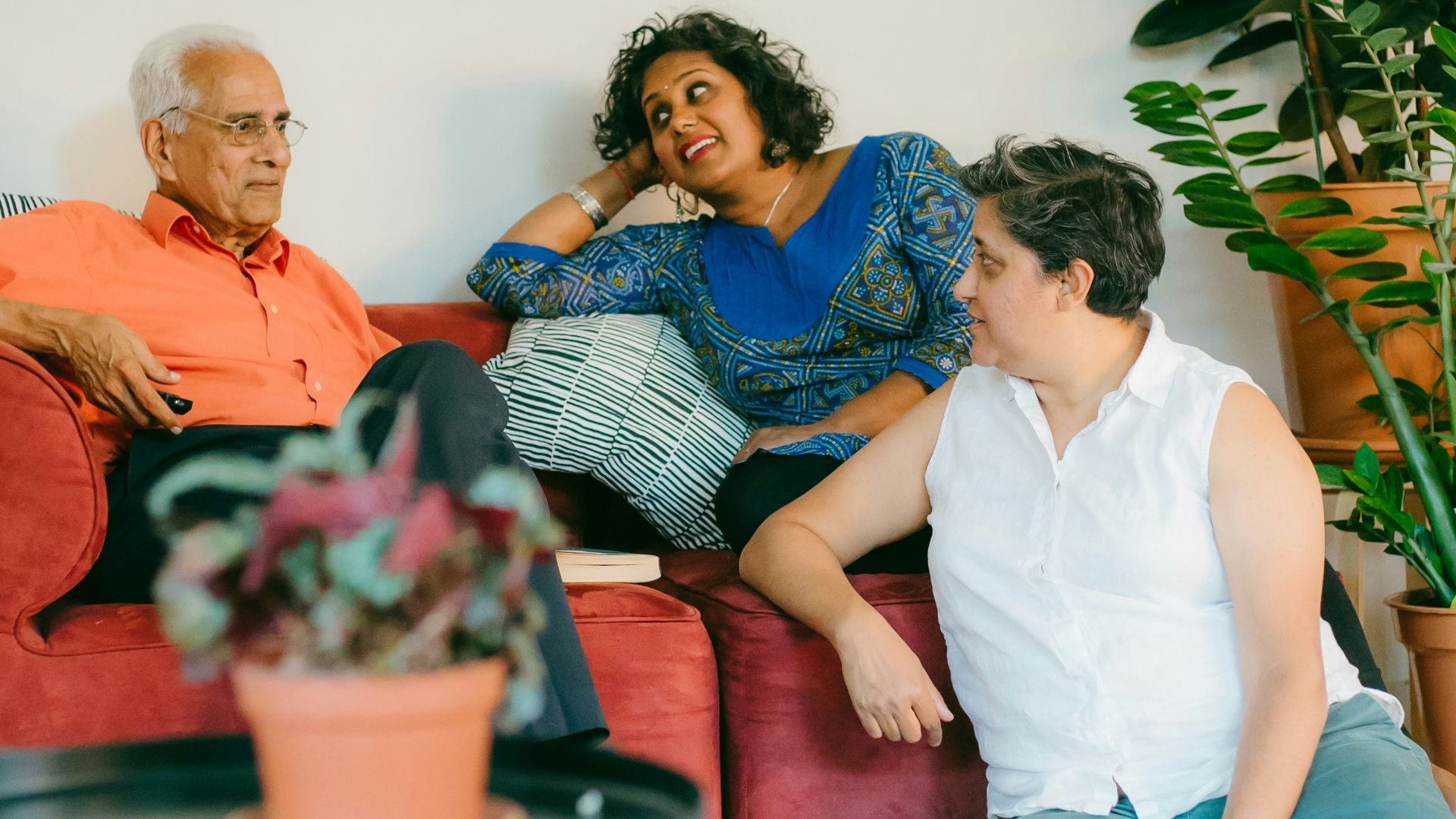 a woman sitting on top of a red couch next to a man