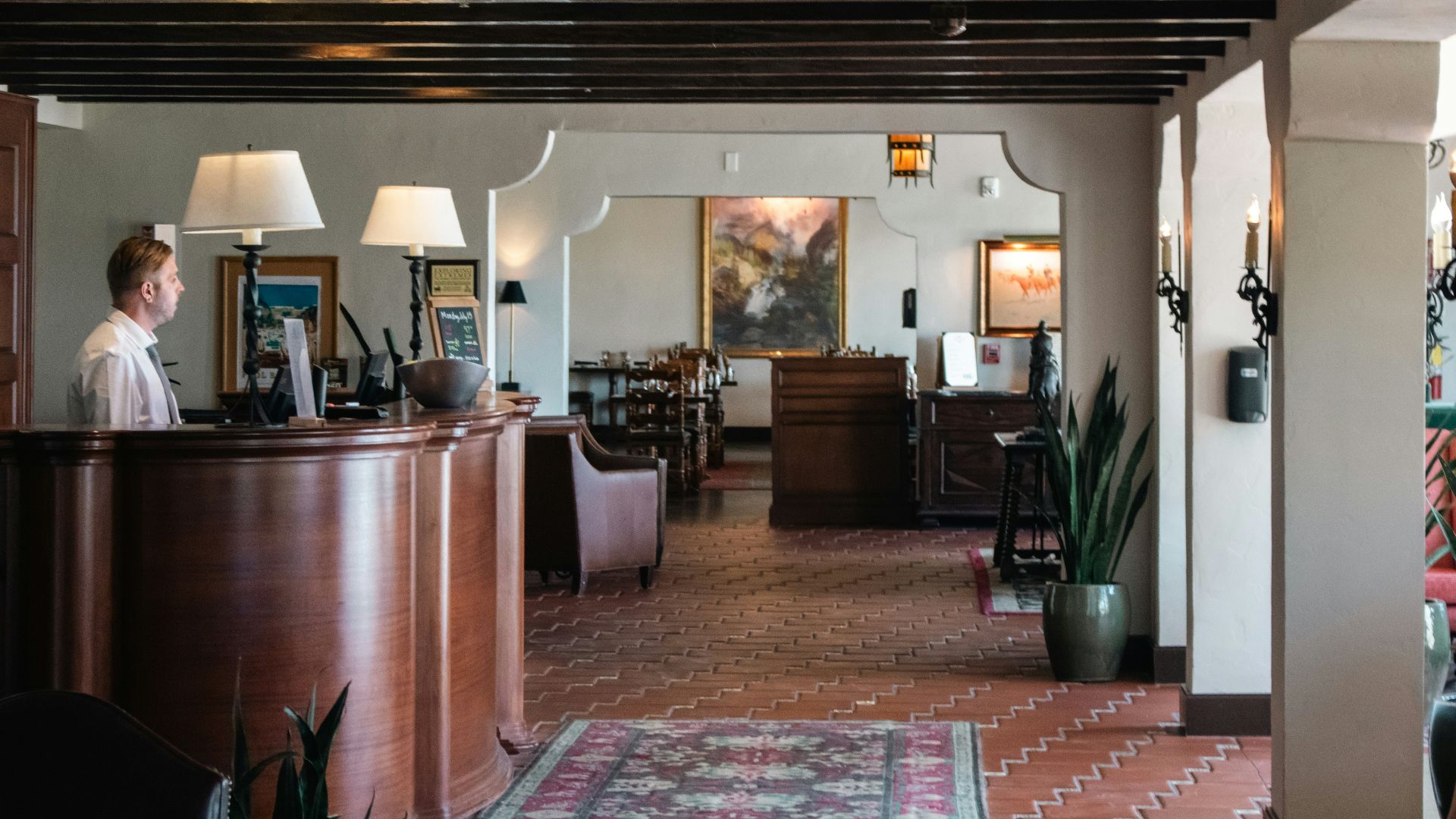A woman is standing at the front desk of a restaurant