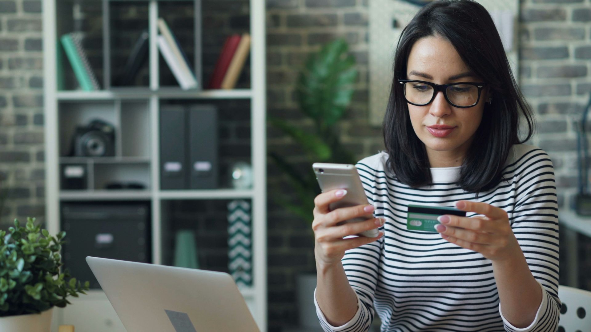 a woman sitting at a table looking at her cell phone