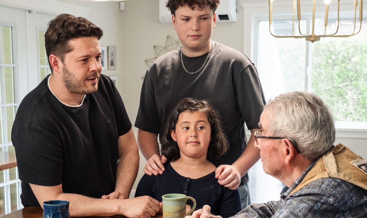 A close-knit family shares a moment around a kitchen table, fostering connection and tradition