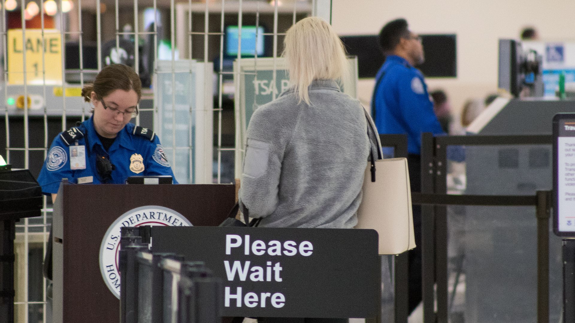 A Transportation Security Administration agent at a checkpoint verifying passenger identification, John Glenn Columbus International Airport