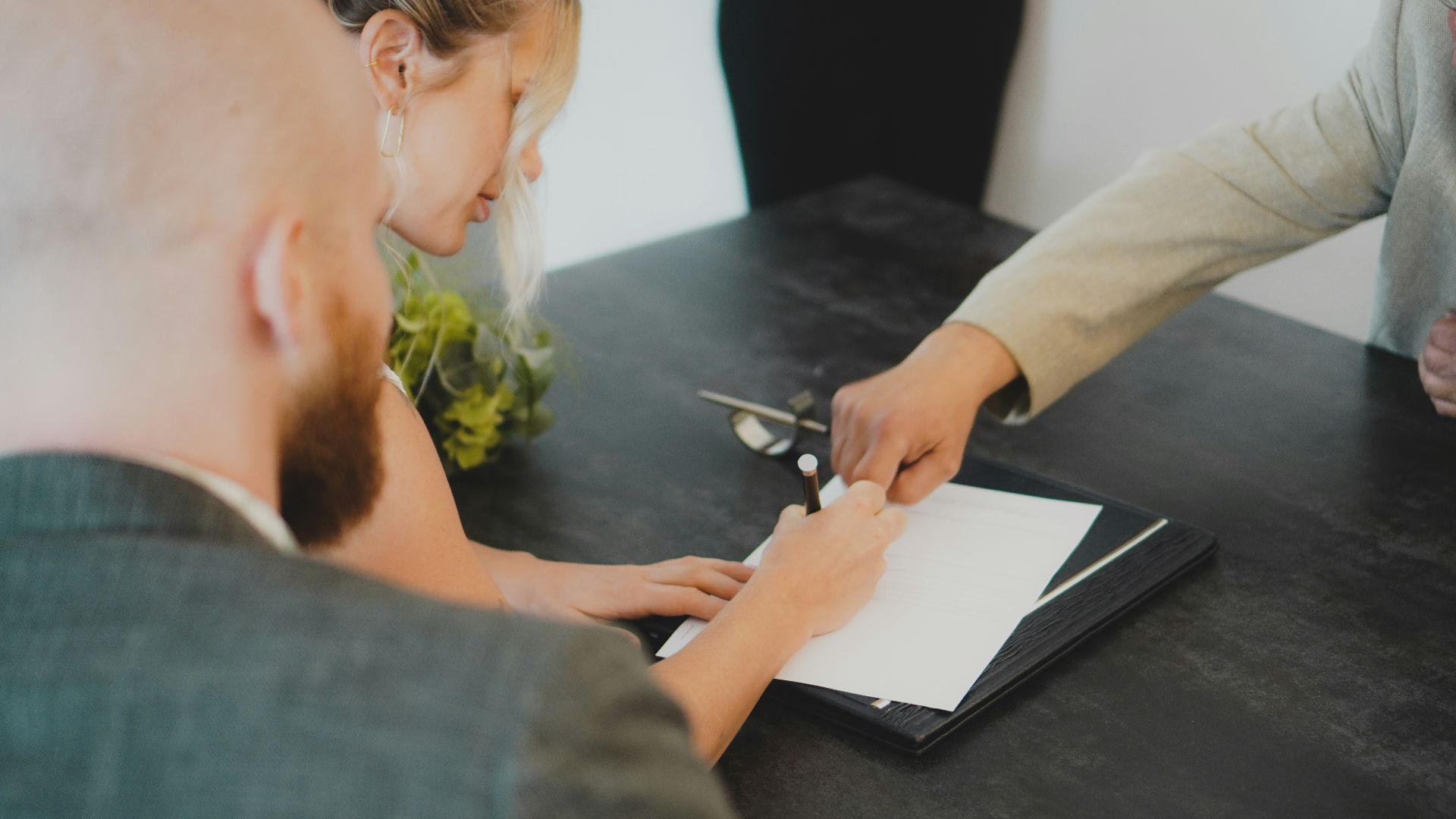 couple signing document at desk