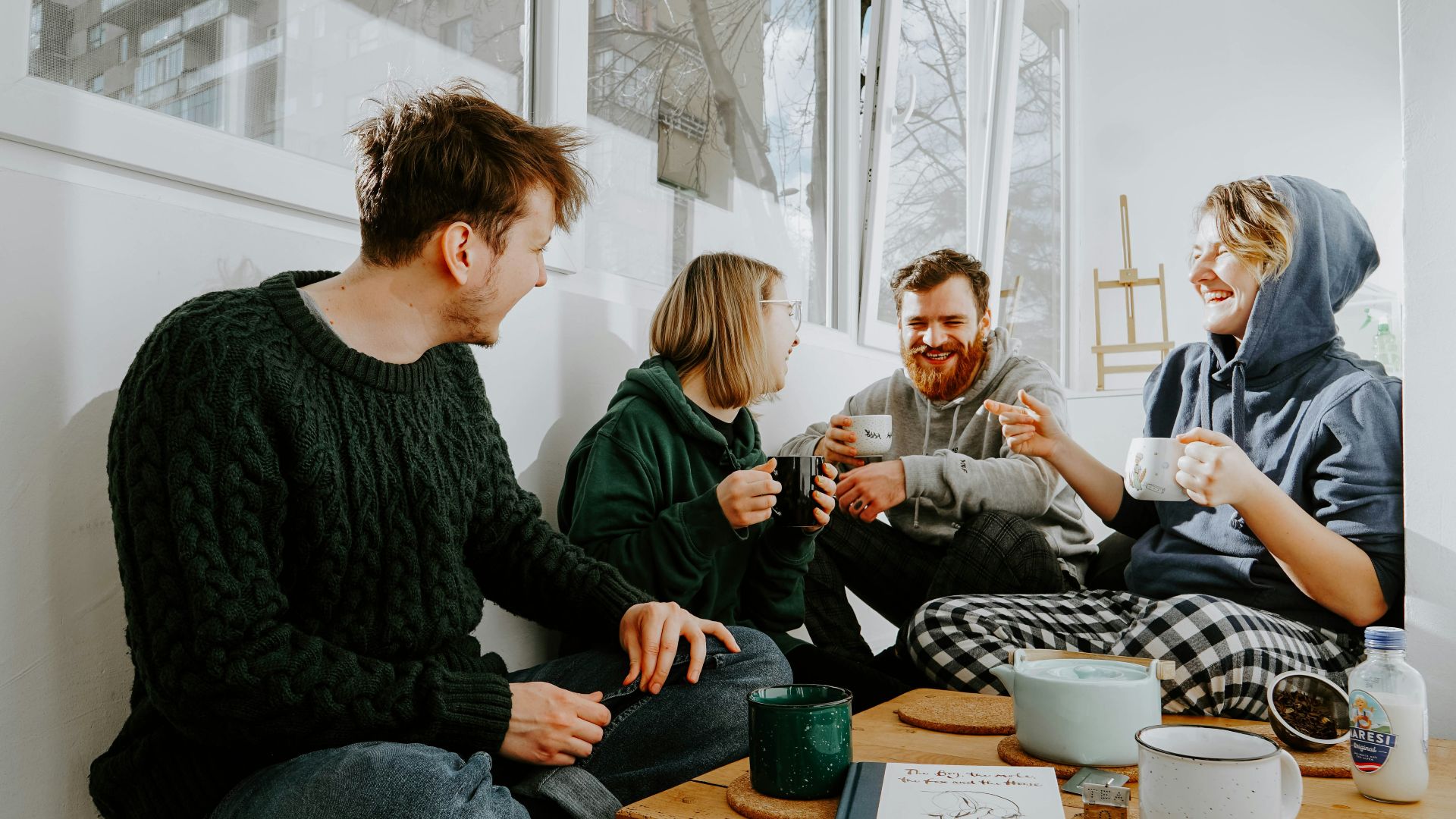 3 women and 2 men sitting on brown wooden table