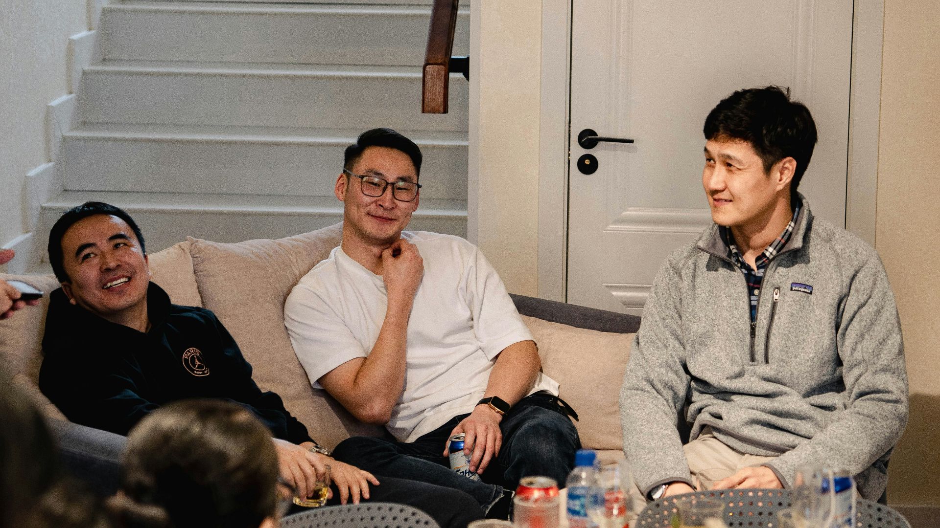 Three men sitting on a couch talking