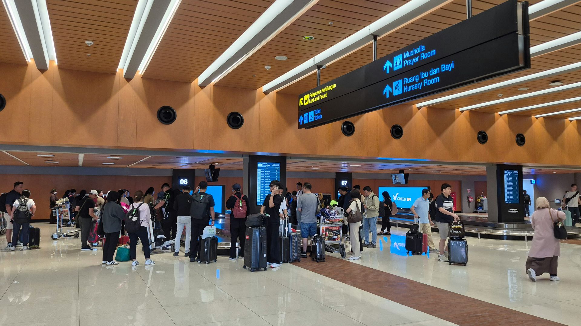 Travelers with luggage waiting in a modern airport terminal