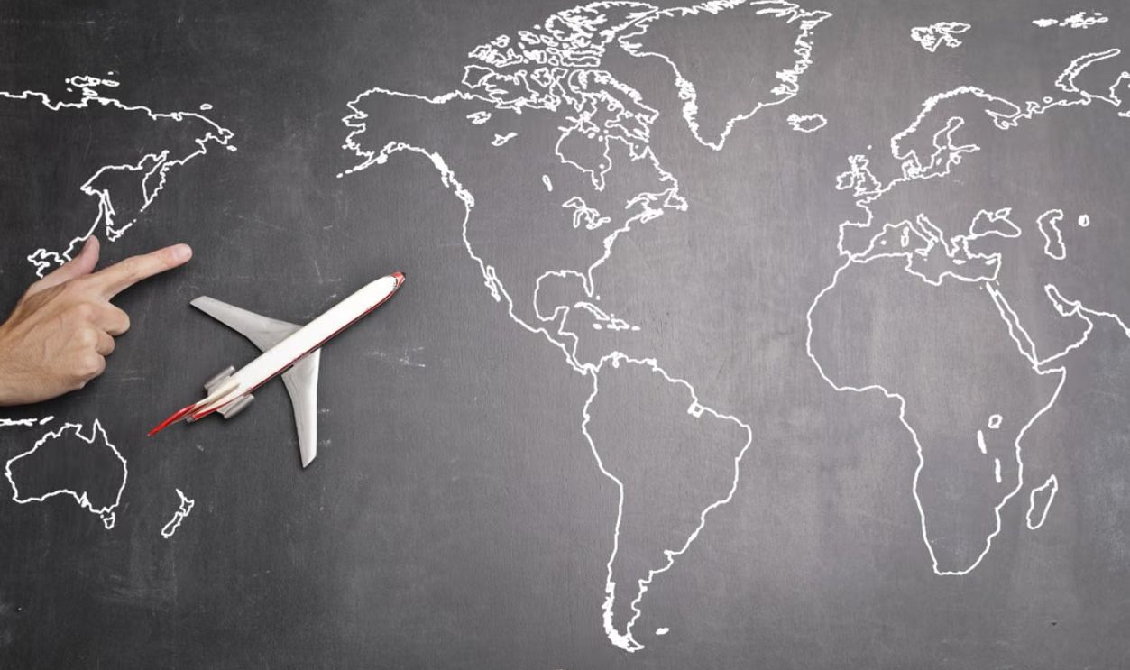 Airplane toy placed on a chalk drawn world map indicating travel and exploration.