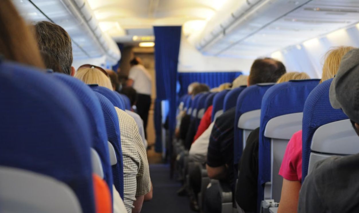Interior view of an airplane cabin with passengers seated, showcasing air travel experience