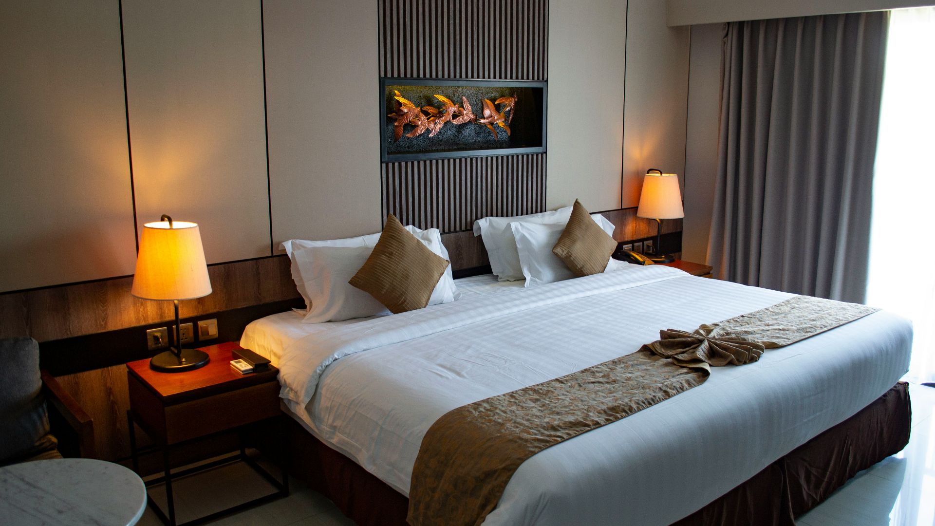 white bed linen with throw pillows