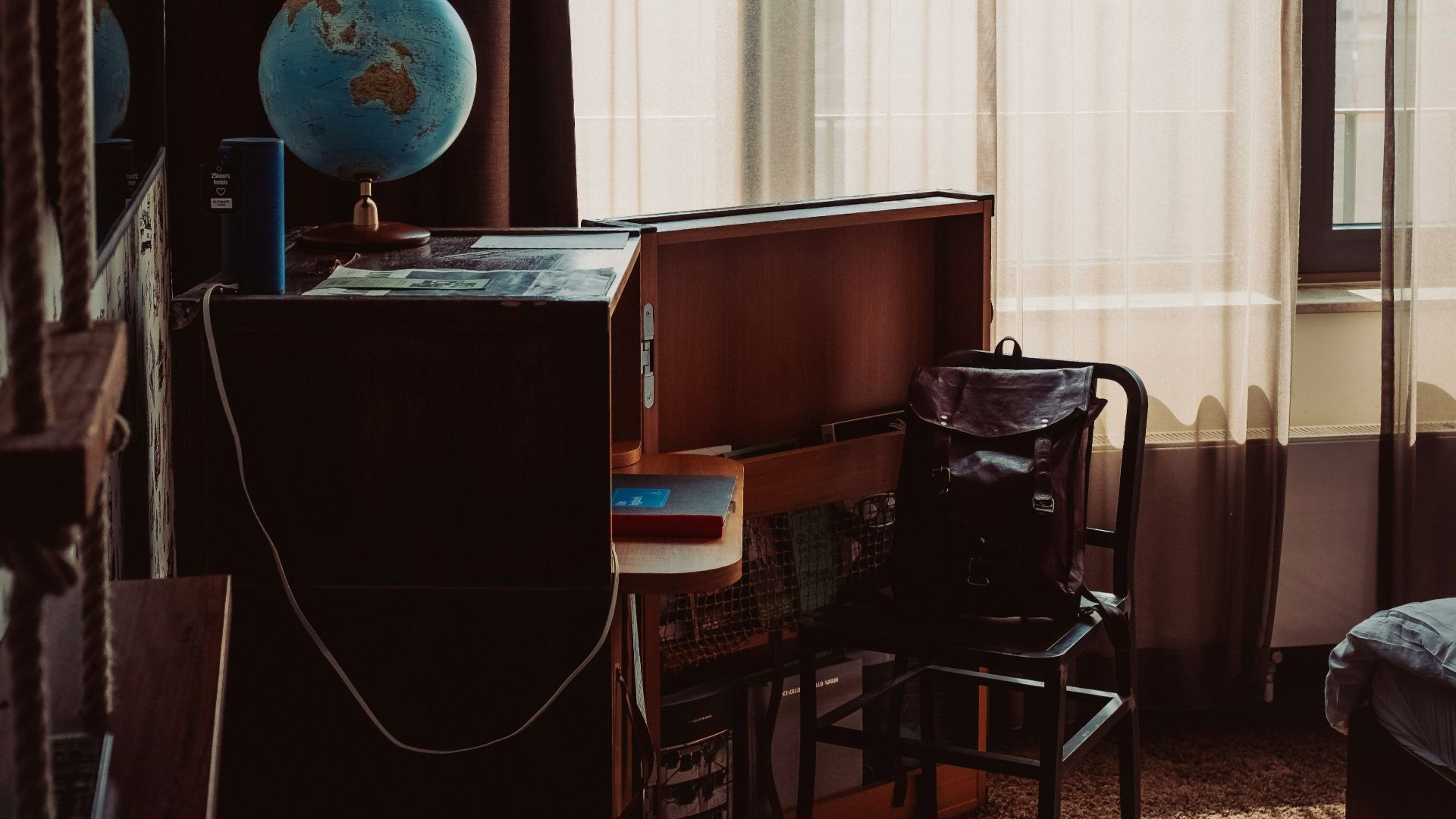 a bedroom with a bed, desk, chair and window