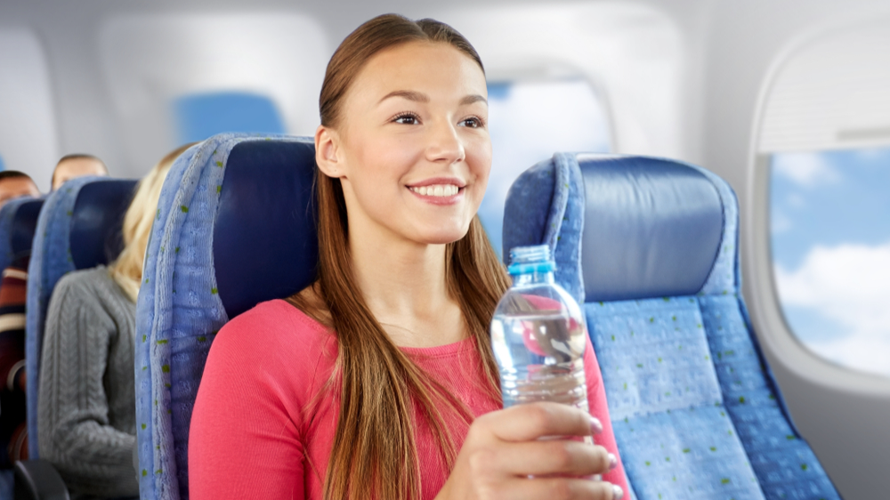 woman with water bottle in plane